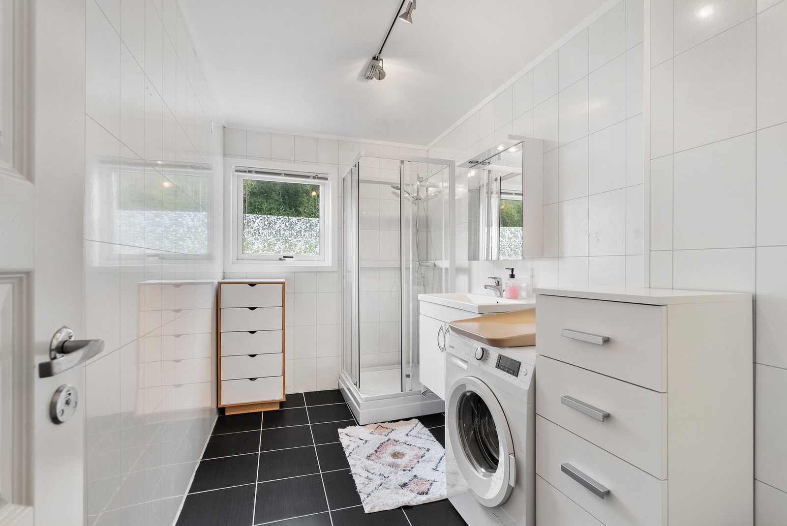 Pent bad, utstyrt med vegghengt innredning, dusj og opplegg for vaskemaskin Galleribilde