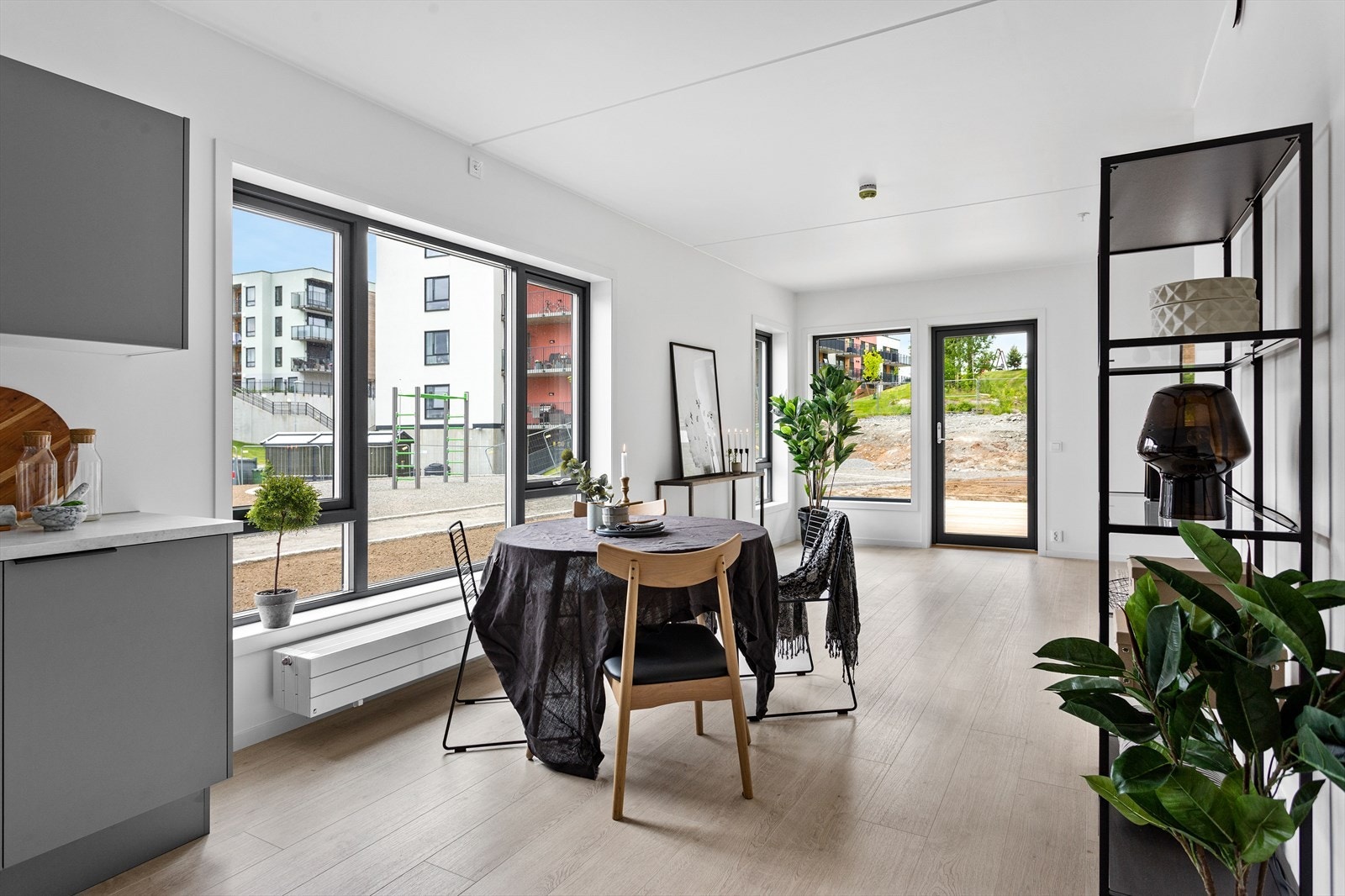 Lys spisestue med store vinduer og utgang til uteområde. Galleribilde