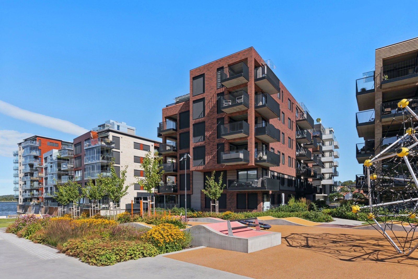 Fasaden fra parken med lekepark og strand Galleribilde