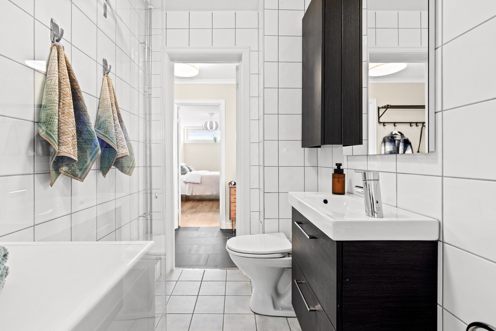 Pent flislagt bad med varmekabler i gulv. Borettslaget gjennomførte rørfornying med våtromsrehabilitering i 2007. Galleribilde