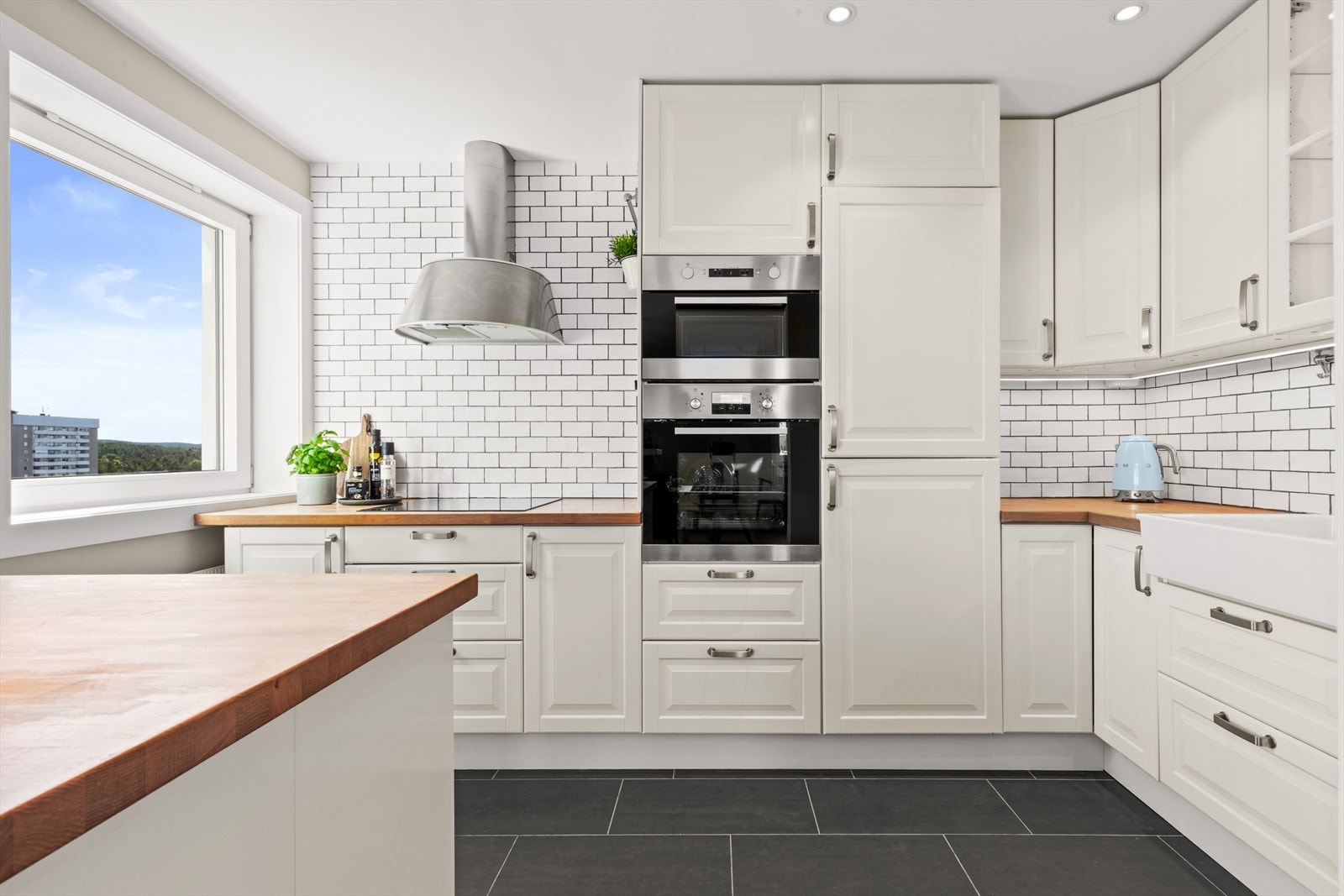 Tilbake i boligen tar vi turen til kjøkkenet. Boligen har et pent kjøkken med skap- og benkeplass. Videre har kjøkkenet varmekabler i gulvet. Galleribilde