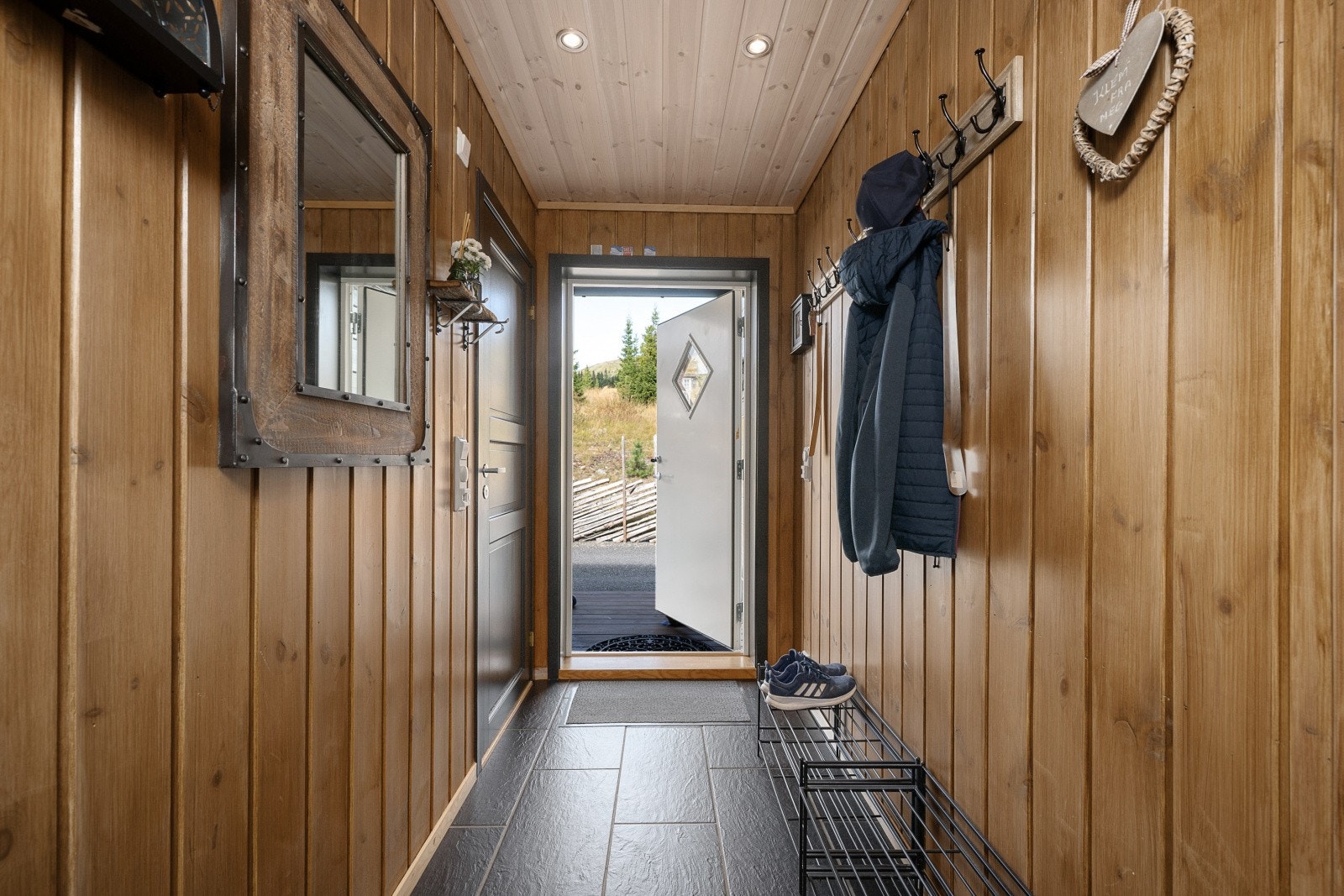 Flislagt entré med behagelig gulvvarme og plass til oppbevaringsløsninger for sko og yttertøy. Galleribilde