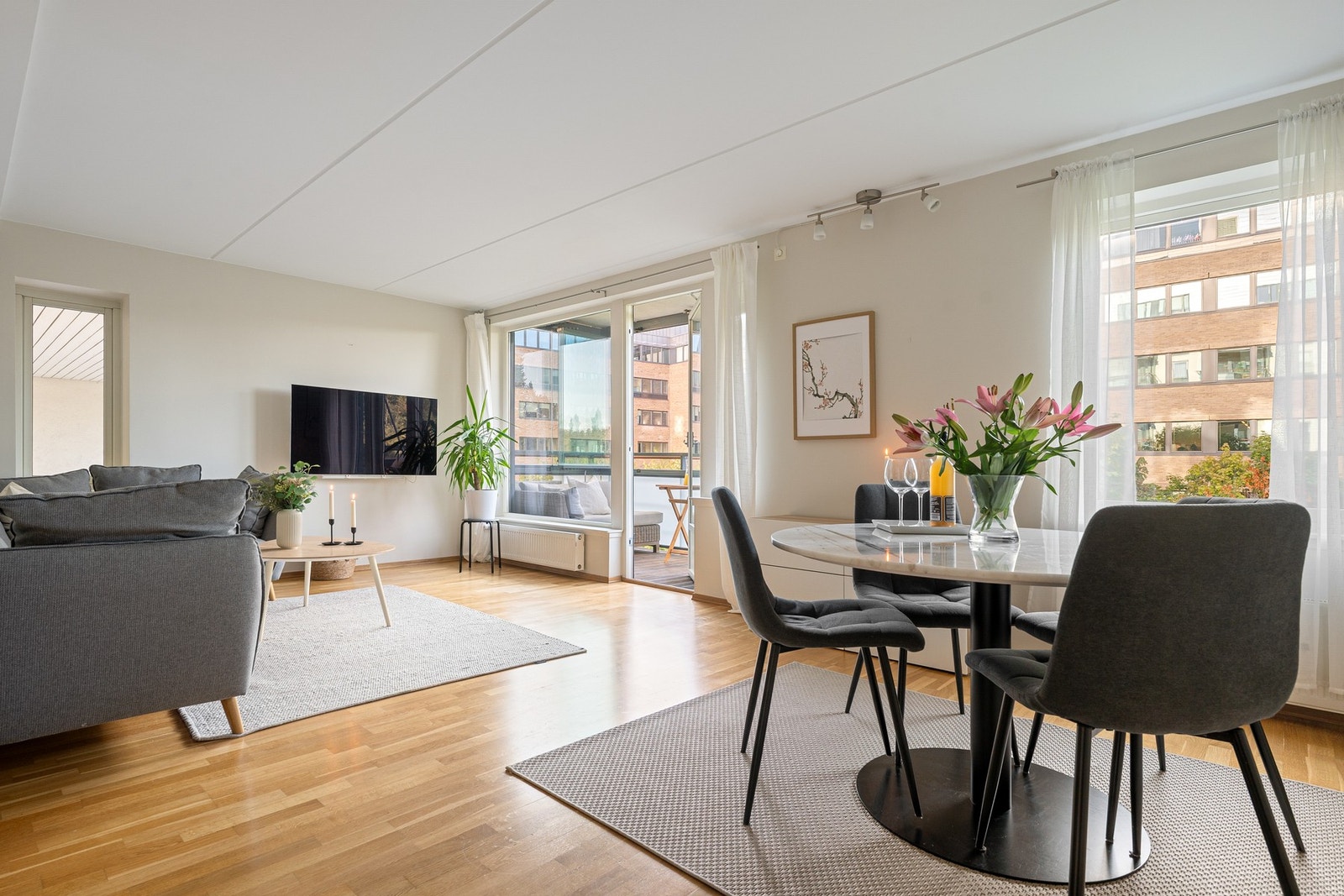 Romslig stue med lyse overflater og pent parkettgulv. Galleribilde