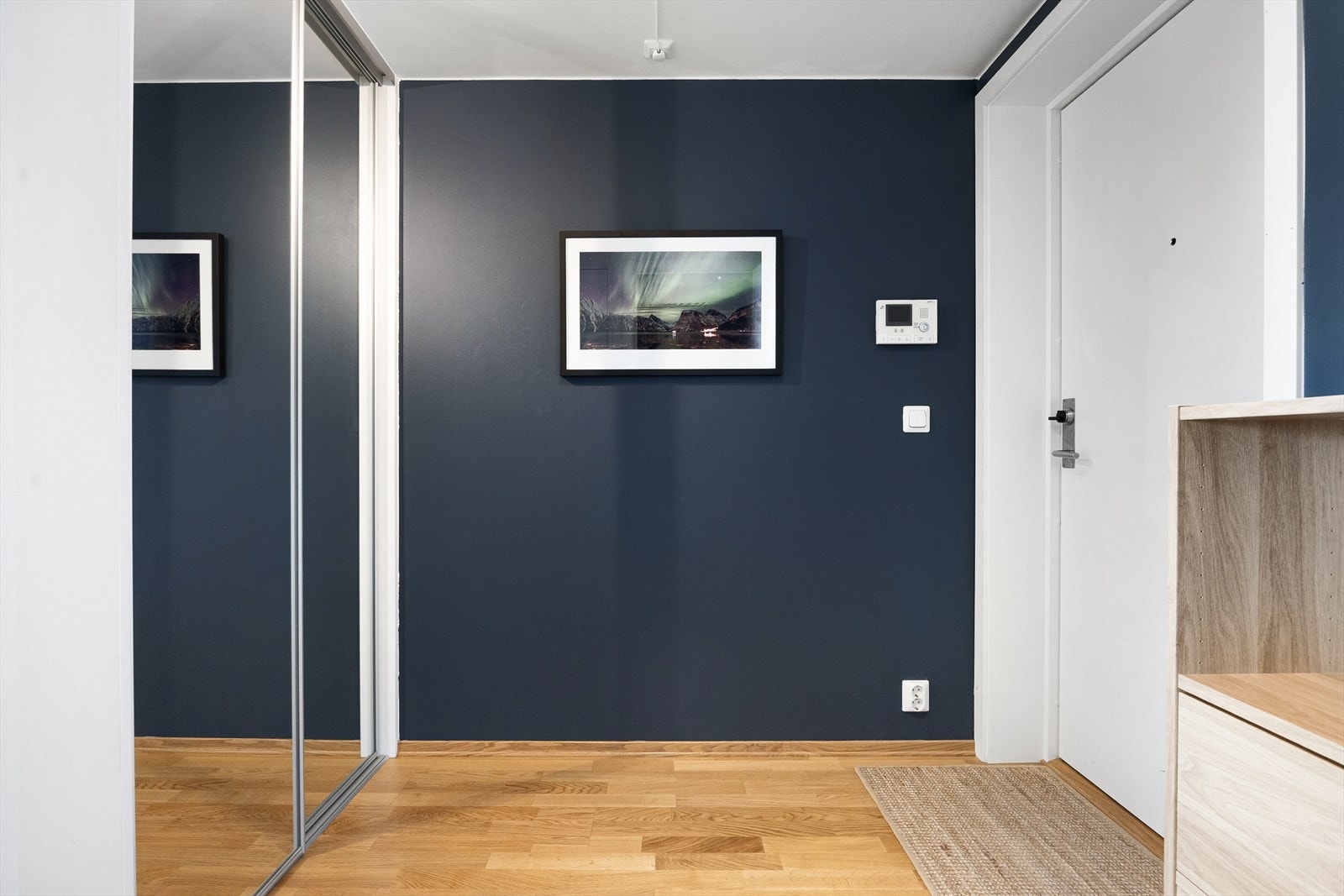 I entréen er det god plass til oppbevaring av yttertøy i en romslig skyvedørsgarderobe med speilfronter. Galleribilde