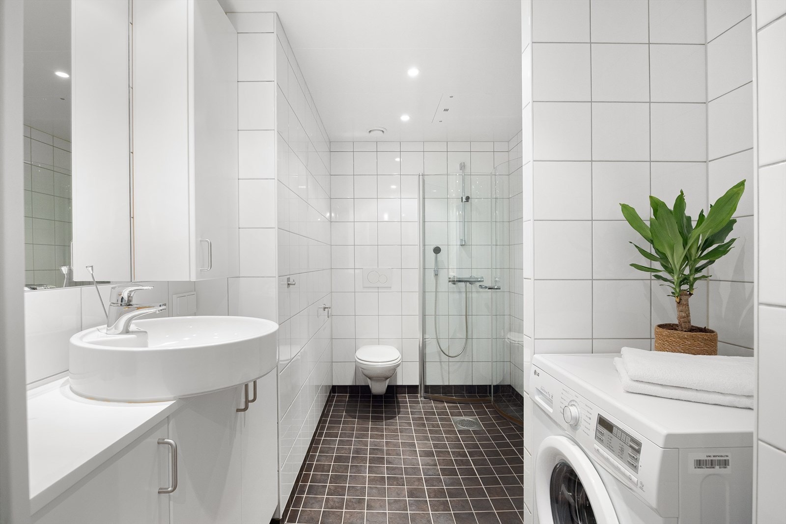 Stilrent, flislagt baderom med gulvvarme og downlights i himling. Praktisk vaskenisje med opplegg for vaskemaskin. Blandebatteri er nytt i 2025. Galleribilde