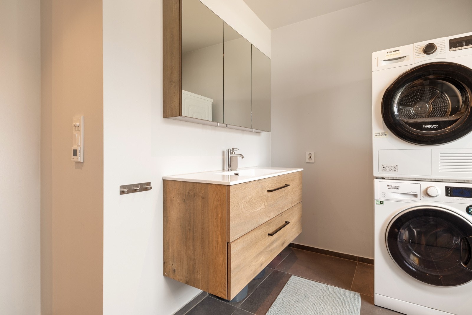 Pen baderomsinnredning med servantskap og speilskap med oppbevaring. Gulvvarme. Galleribilde