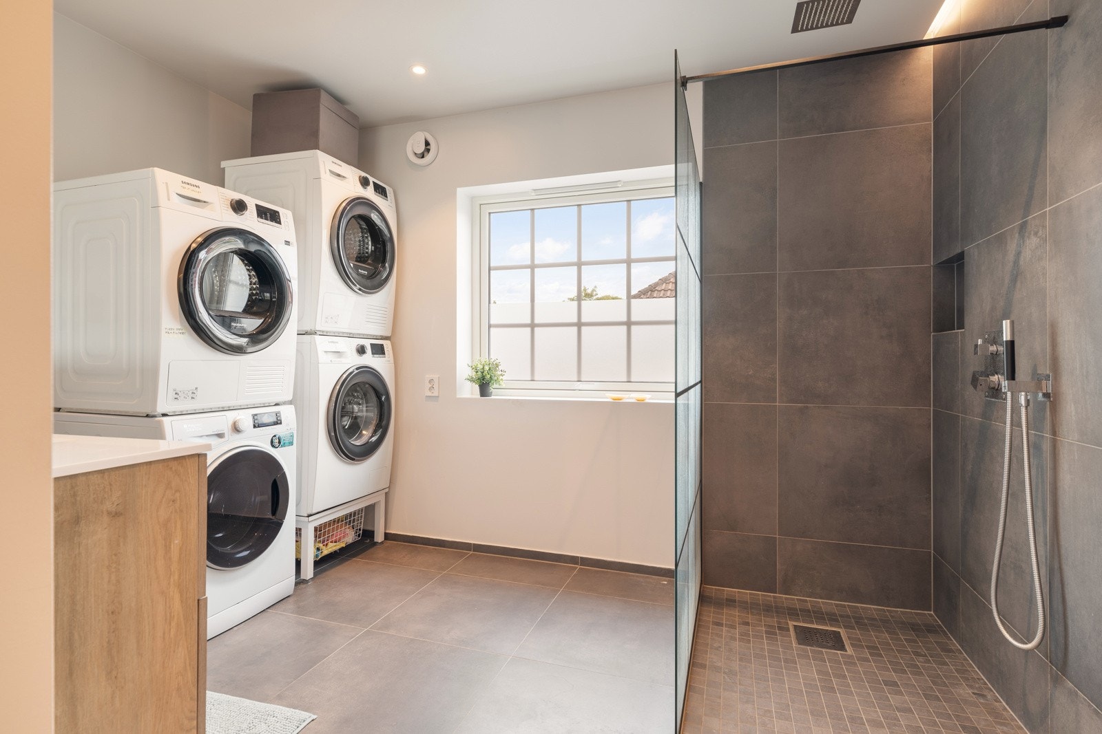 Det andre badet er målt til 8,5 kvm og har et stort dusjhjørne. Opplegg for vaskemaskin og tørketrommel. Galleribilde