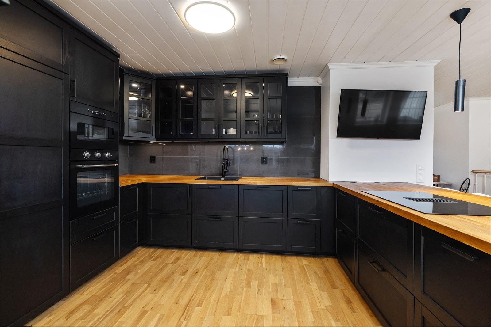Kjøkkenet ble oppgradert i 2022 og har sorte, glatte fronter og en heltre benkeplate. Galleribilde