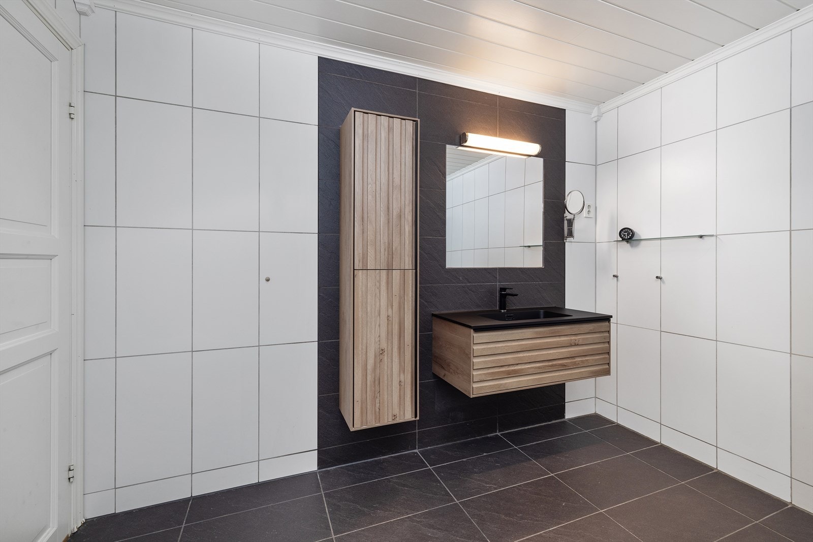 Rommet er innredet med dusjnisje med glassbyggerstein, vegghengt toalett og baderomsinnredning med heldekkende servant. Galleribilde