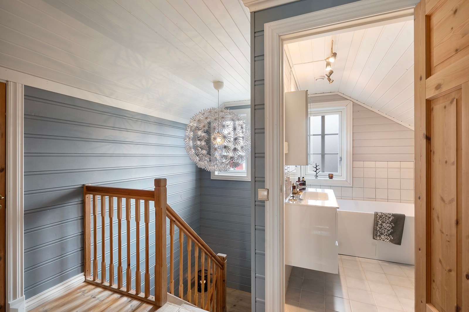 Det er en lys og åpen trappegang med panel som er malt i lun farge Galleribilde