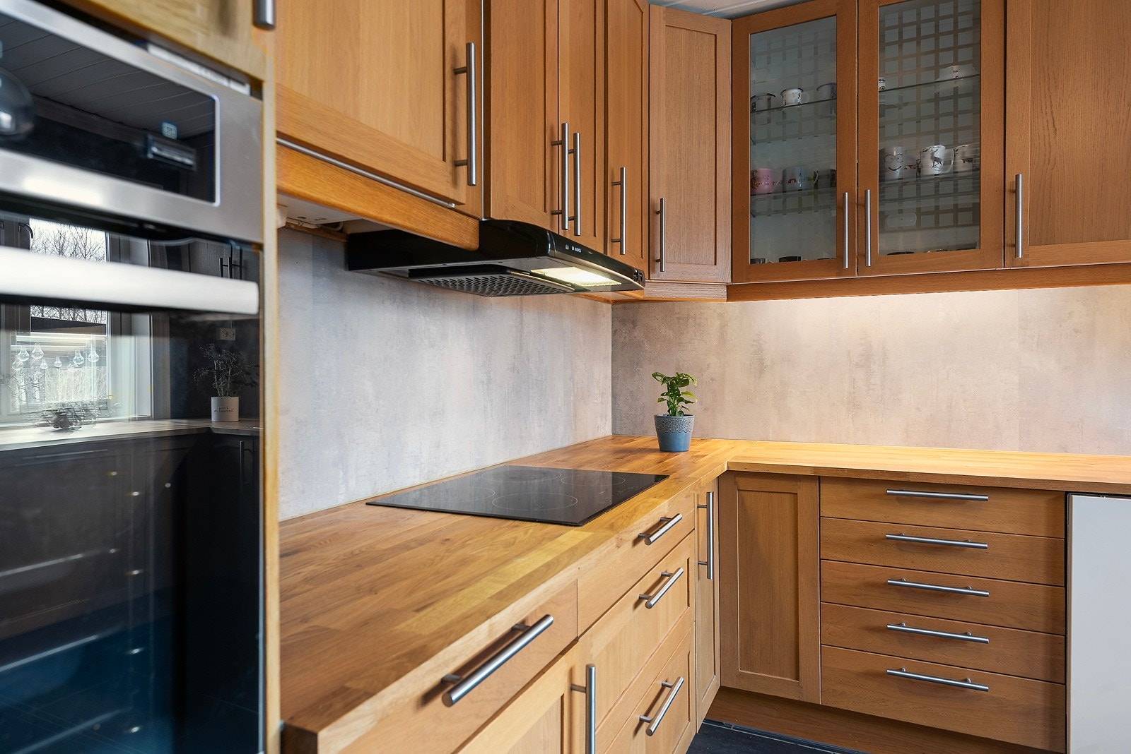 Her har du benkeplater av heltre, integrert kjøleskap, komfyr og platetopp Galleribilde