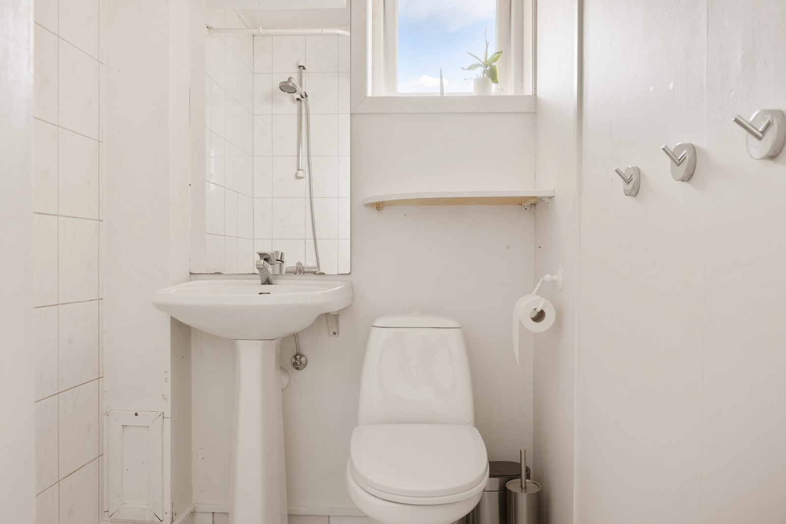 Praktisk baderom med dusjhjørne, toalett og opplegg for vaskemaskin. Galleribilde