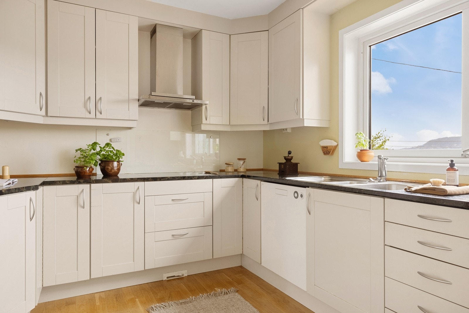 Funksjonelt kjøkken med induksjonstopp, stekeovn, kjøleskap/frys og stein benkeplate. Galleribilde