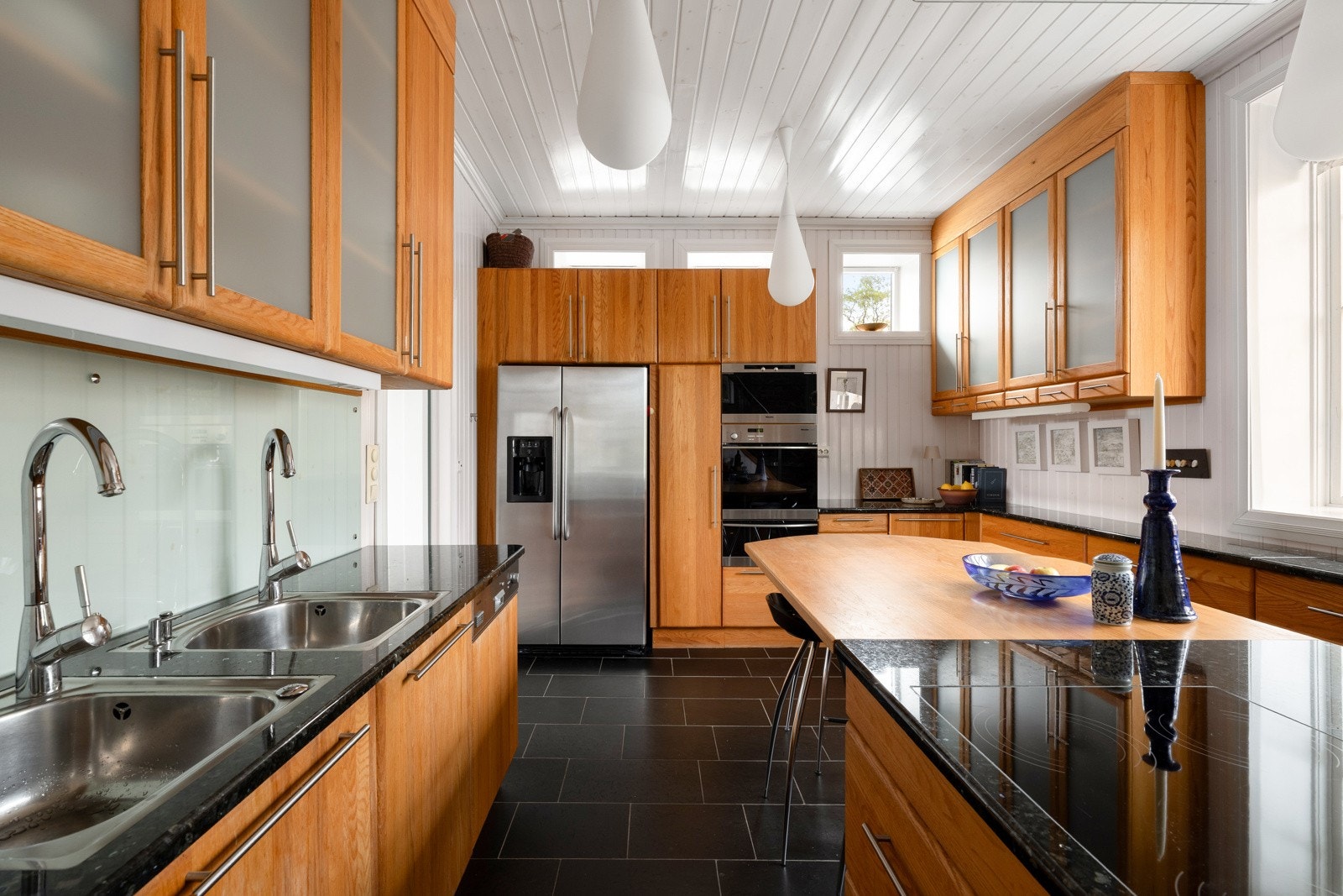 Kjøkkenet har innredning med glatte fronter og en lekker benkeplate av granitt. Galleribilde