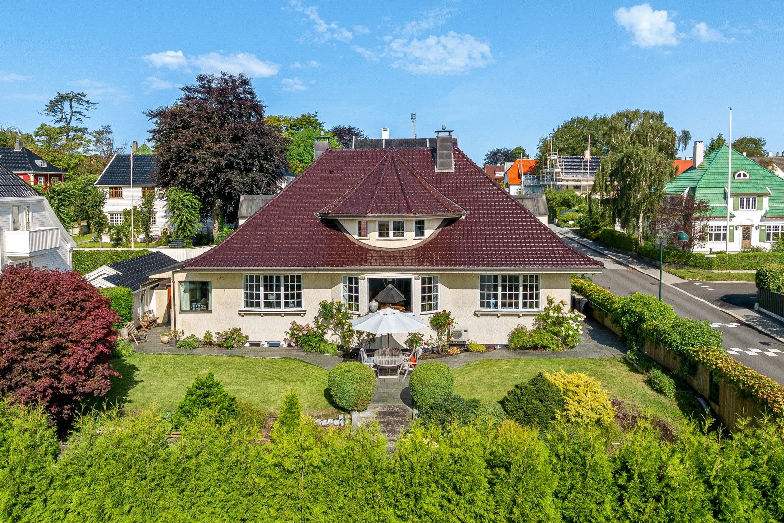 Uteområde er sørvendt og delt inn i to nivåer. På det øverste nivået mot huset er det en nydelig plen omkranset av bed med vakker beplantning og flotte skiferheller. Galleribilde
