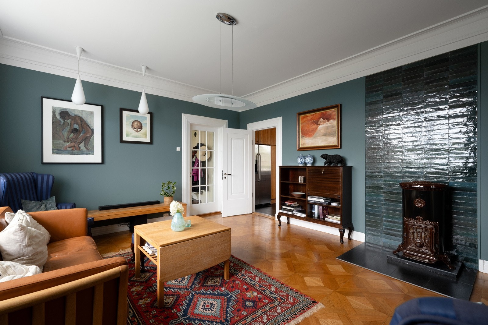 Koselig stue ved spisestuen og kjøkkenet har en dekorativ koksovn som var ny i 2021. Galleribilde