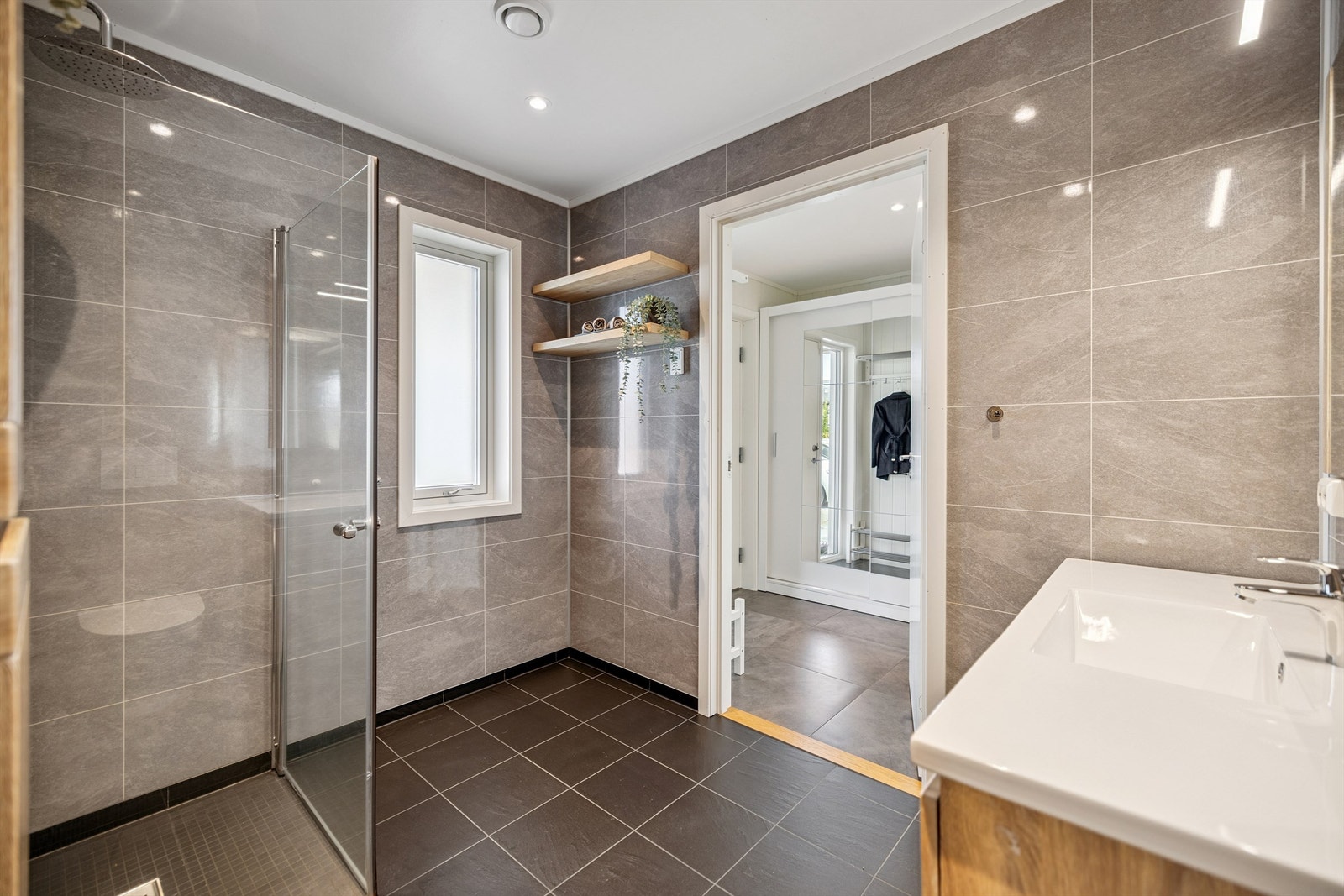 Badet har fliser på gulv og baderomsplater på veggene. Galleribilde