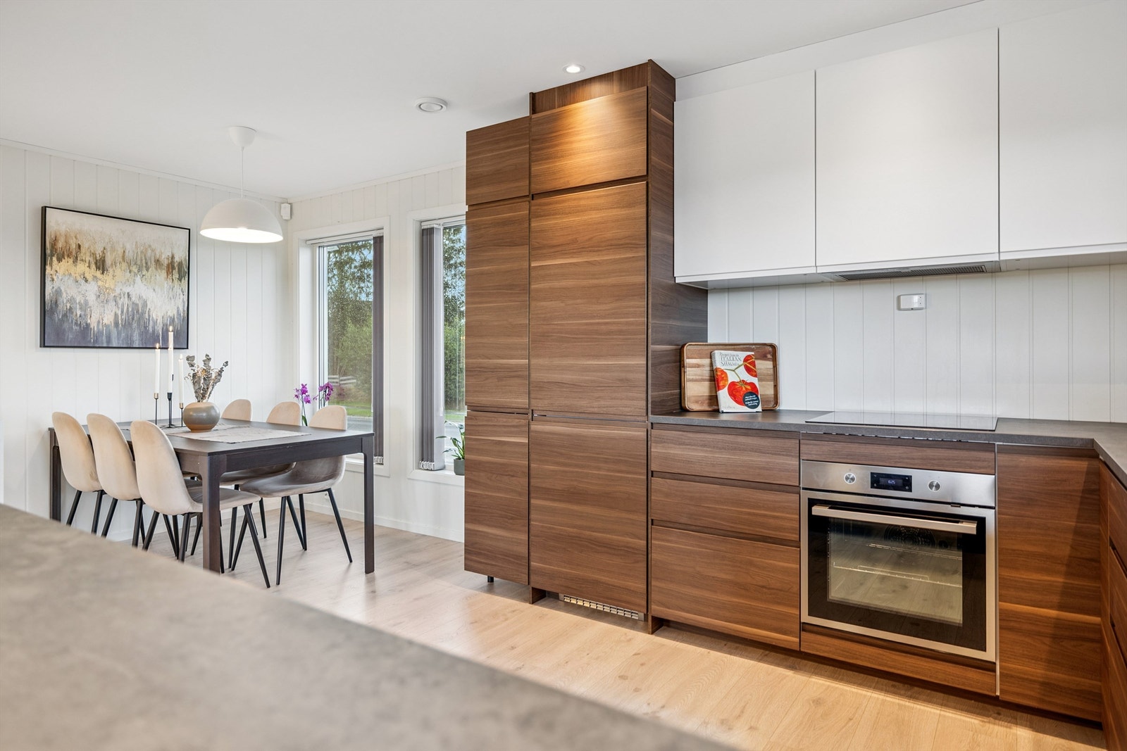 Stilrent kjøkken med slette fronter og integrerte hvitevarer. Galleribilde