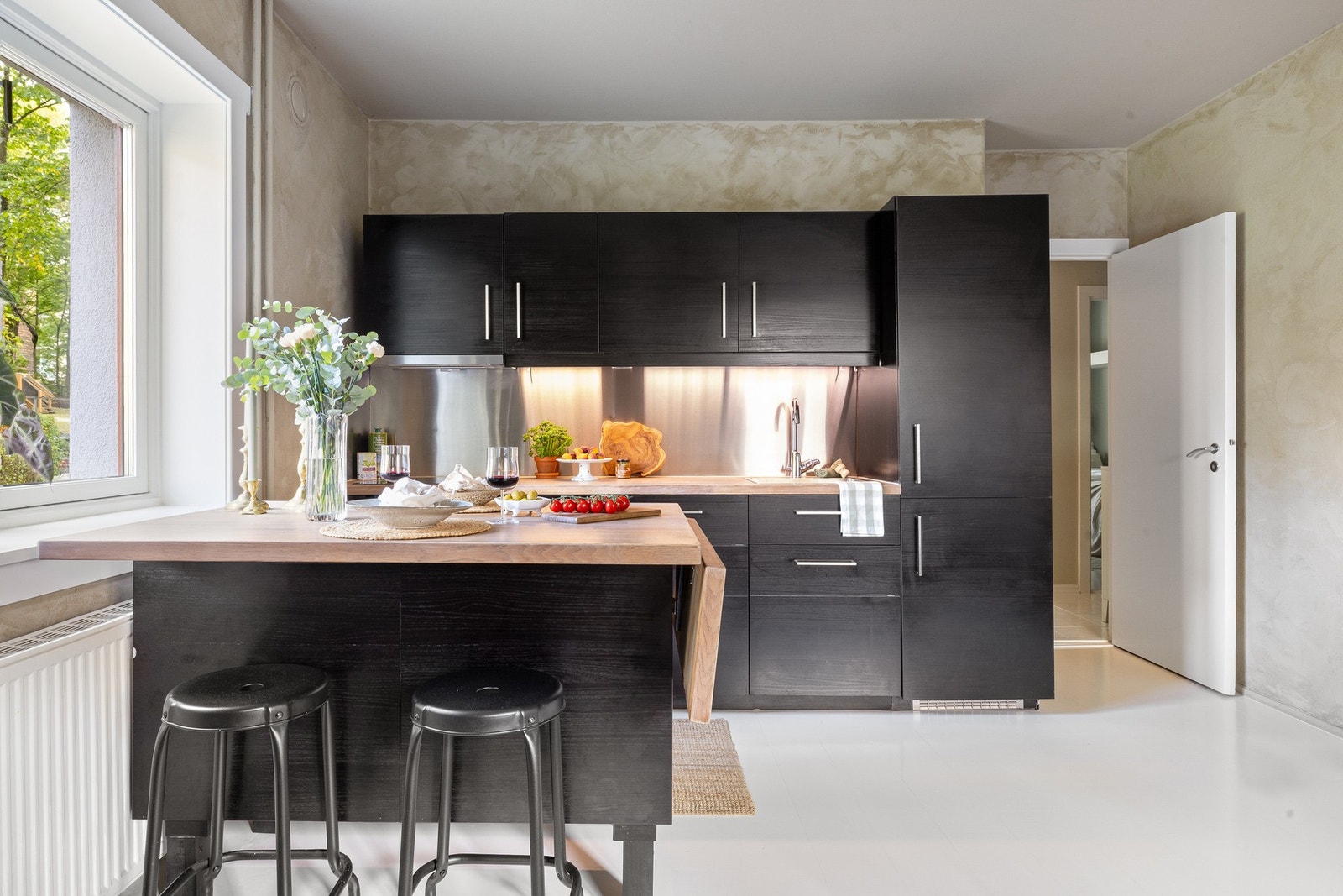 Kjøkkenet har slette fronter og benkeplate i heltre. Integrerte hvitevarer medfølger Galleribilde