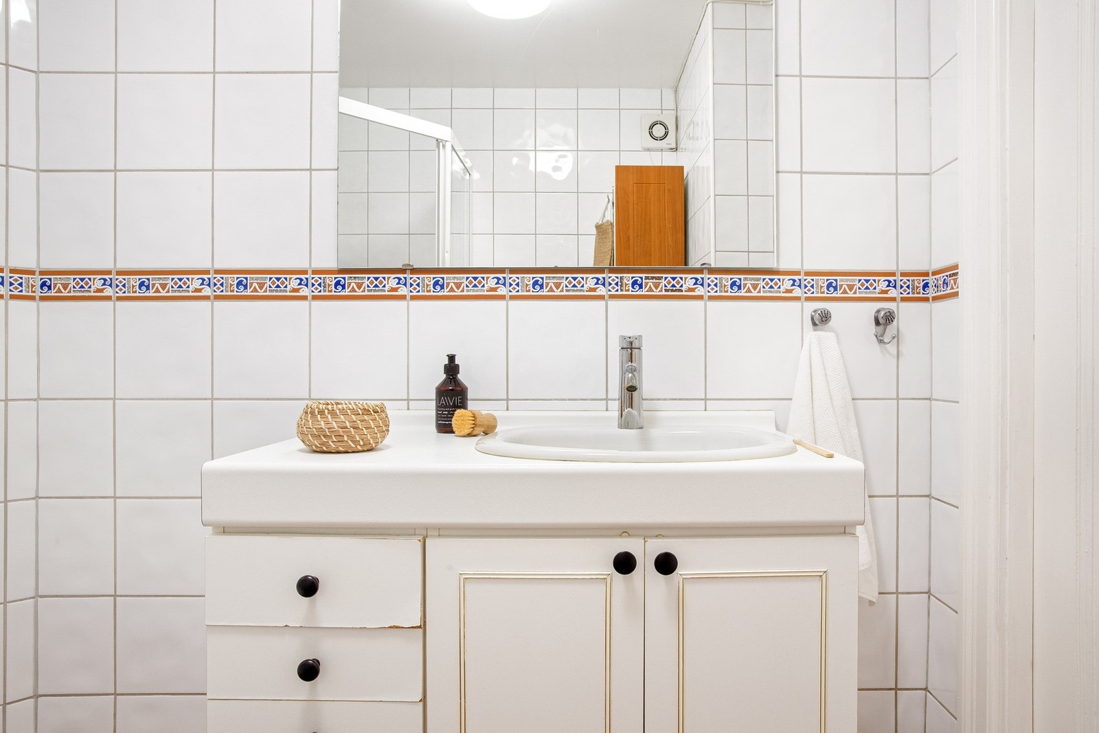 Badet er helfliset og innredet med dusjhjørne, toalett og servant med baderomsinnredning. Galleribilde