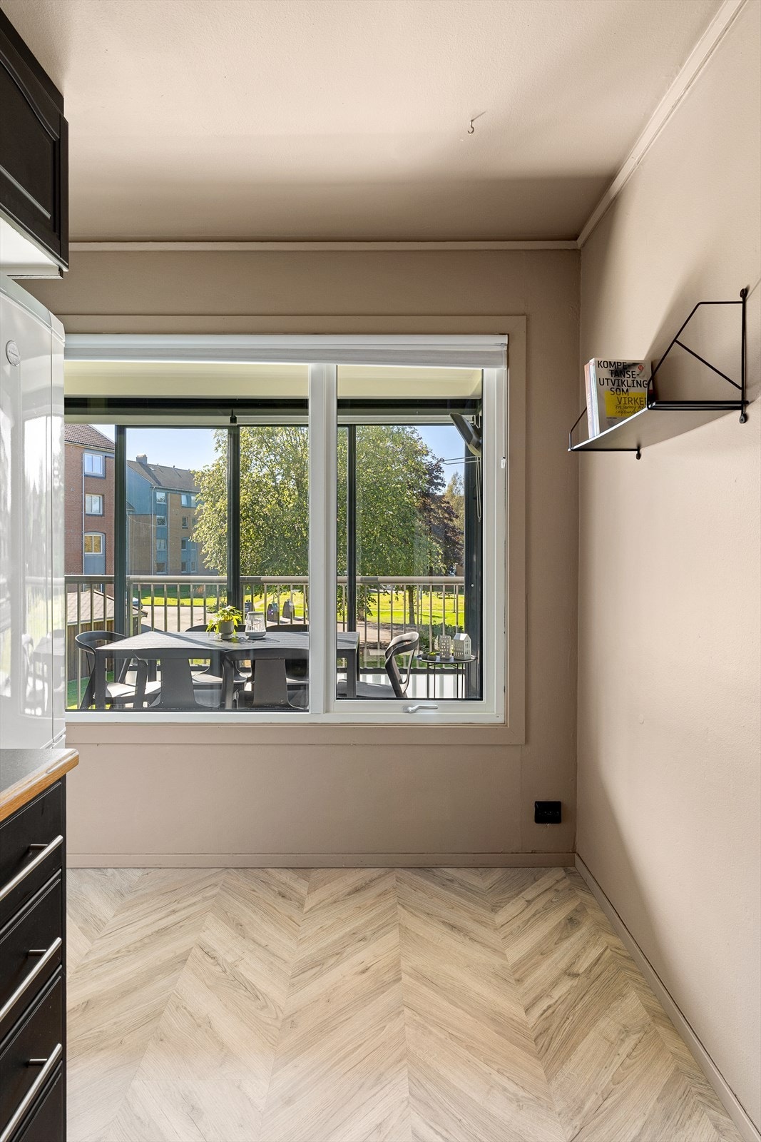 Lyst kjøkkenområde med direkte utgang til innglasset balkong. Galleribilde