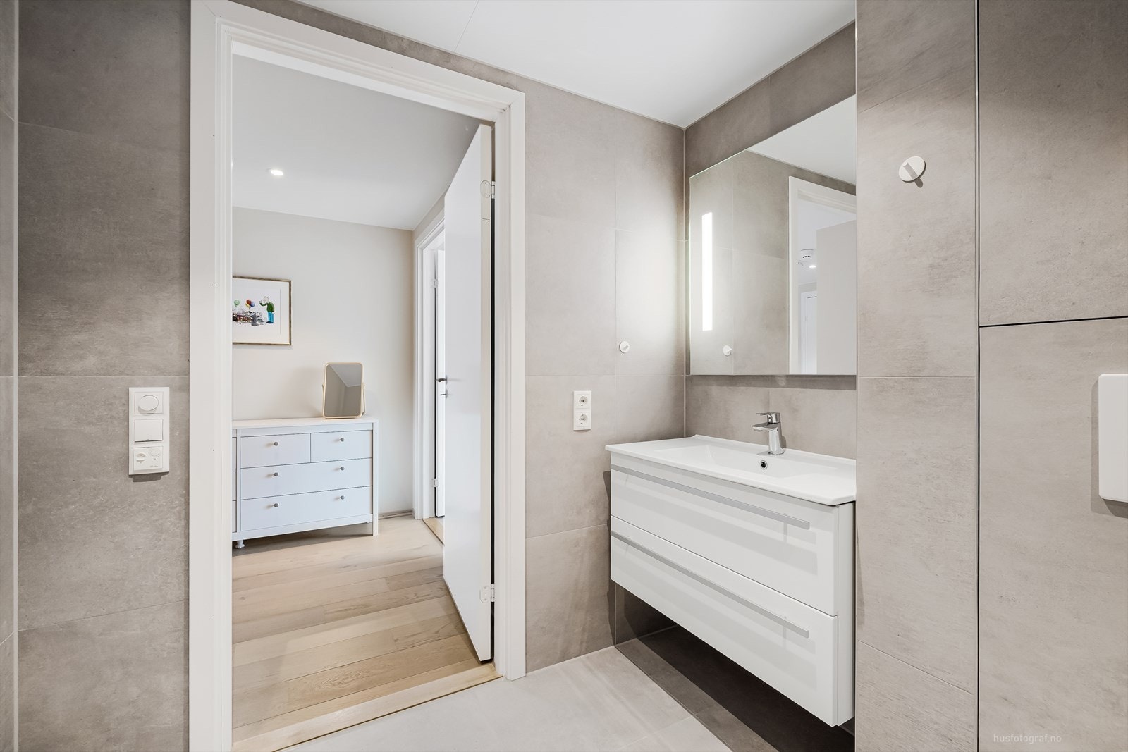 Rommet har innredning med heldekkende servant, speil med integrert belysing, toalett, dusjhjørne og opplegg for vaskemaskin Galleribilde