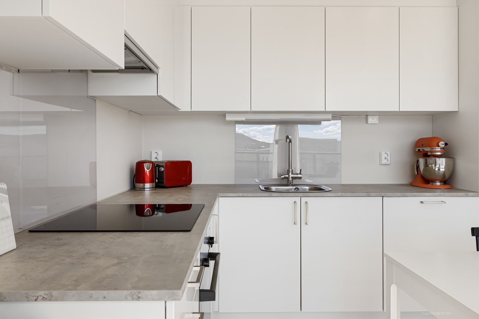 Over vask og platetopp er det montert plate for å hindre sprut og søl Galleribilde