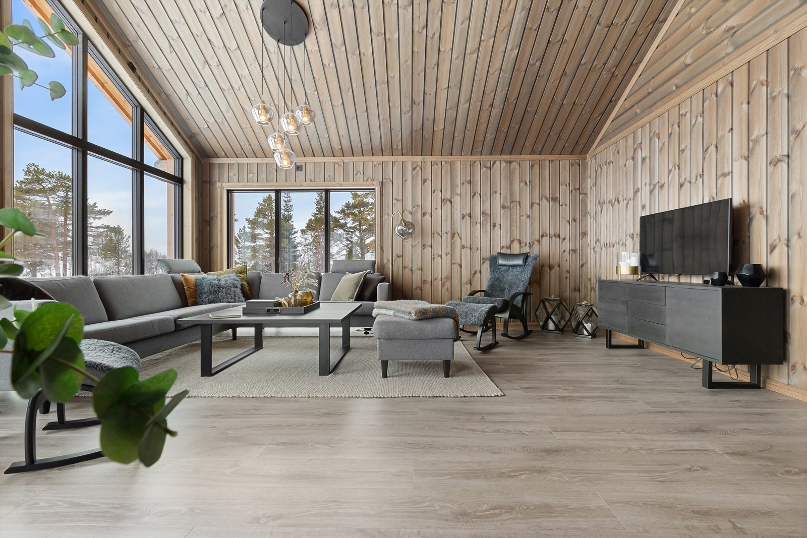 Den romslige stuen imponerer med sin åpne himlingsløsning og store vindusflater Galleribilde