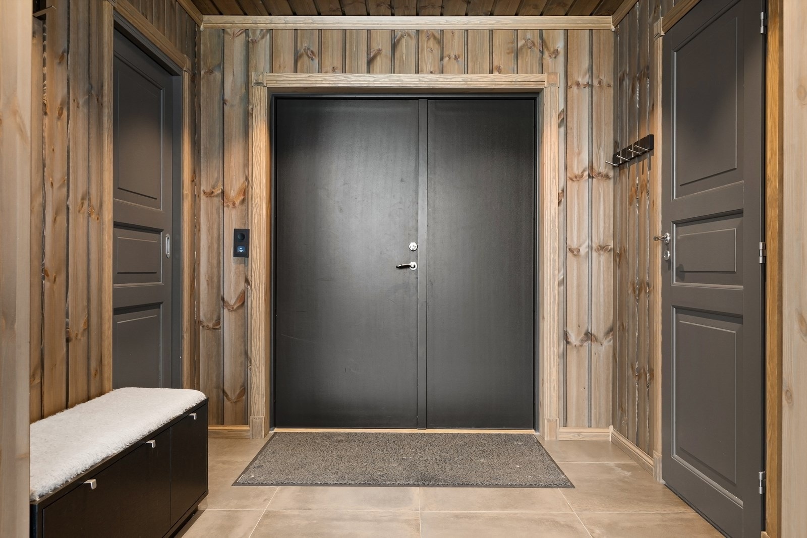 Et lunt og funksjonelt inngangsparti med plass til oppbevaring Galleribilde