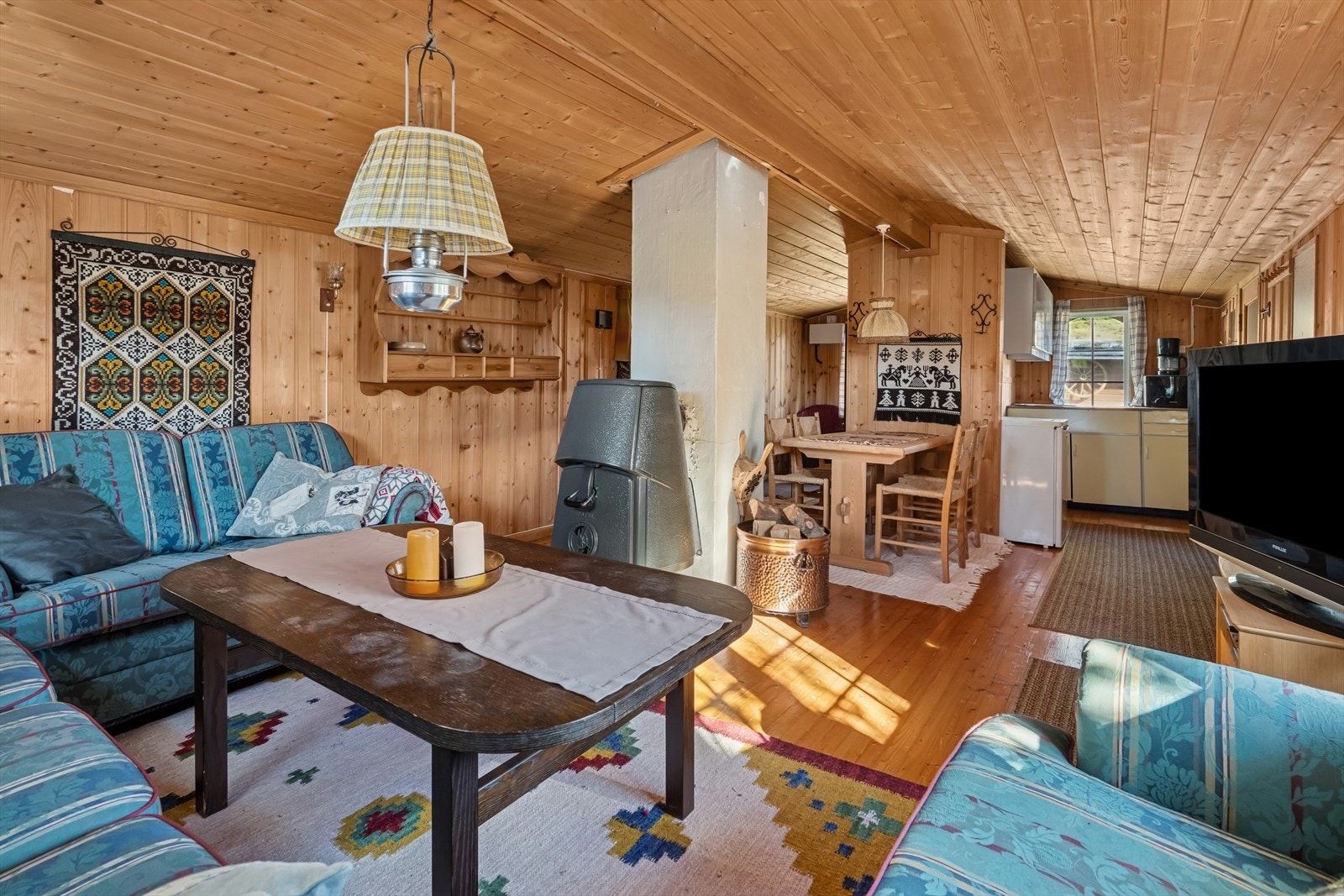 Sentralt i rommet er det sjarmerende peisovn som varmer godt. Galleribilde