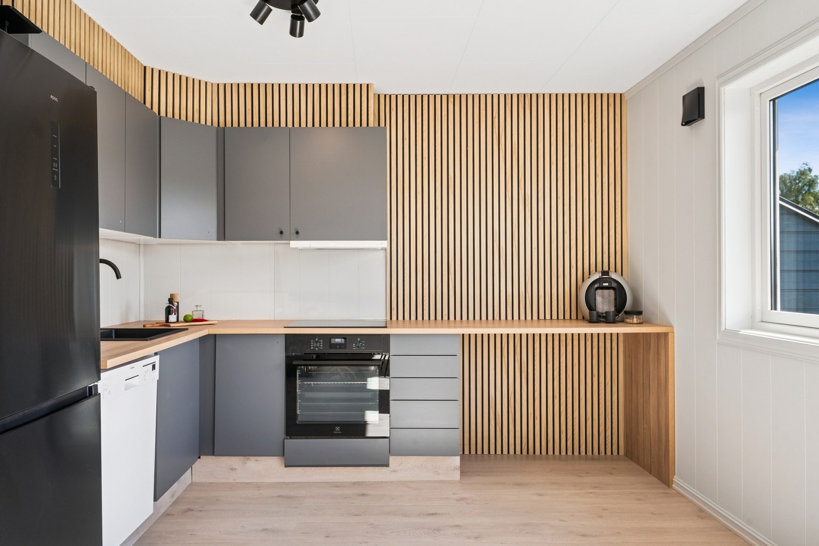 Dette flotte kjøkkenet ligger i åpen løsning mot stuen. Kjøkkenet har en praktisk plass hvor du kan plassere barstoler og nyte frokosten ved benkeplaten. Galleribilde