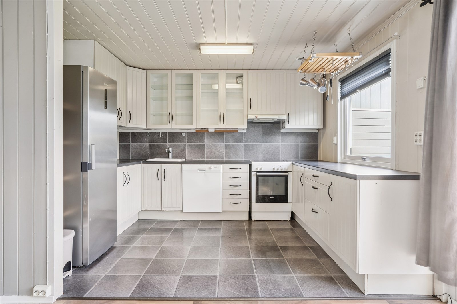 Praktisk kjøkken med takhøy, hesteskoformet innredning og god arbeidsplass. Galleribilde