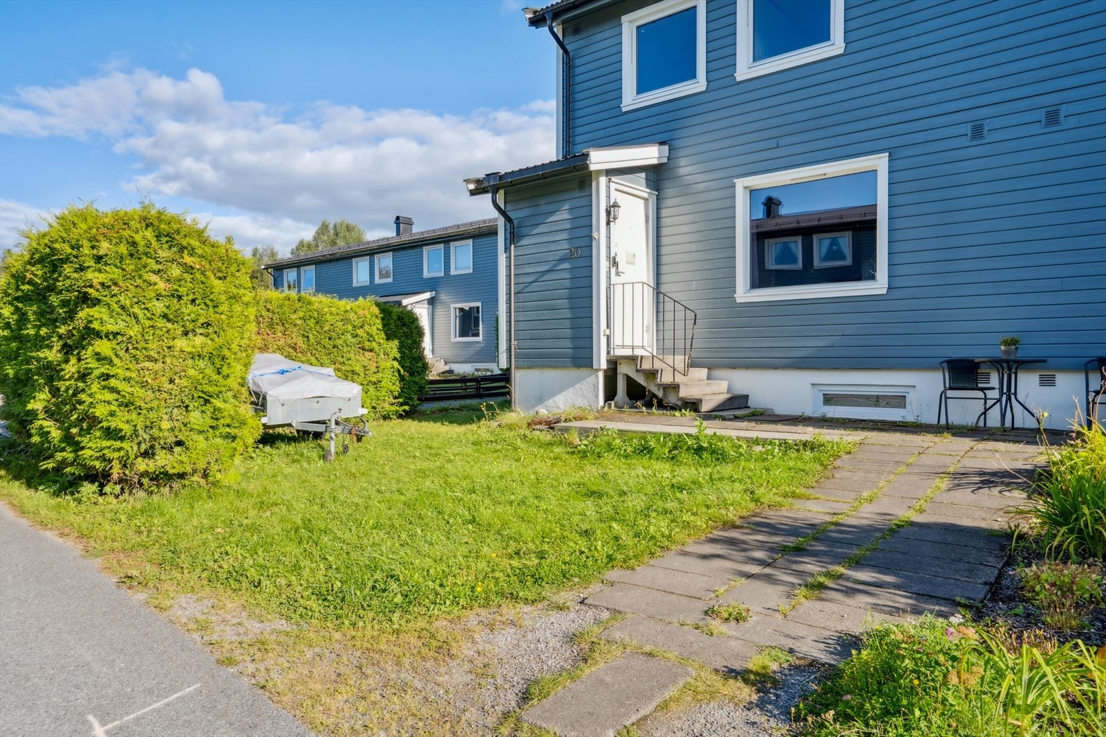 Hellelagt gangsti leder frem til inngangspartiet med en liten hageflekk. Galleribilde