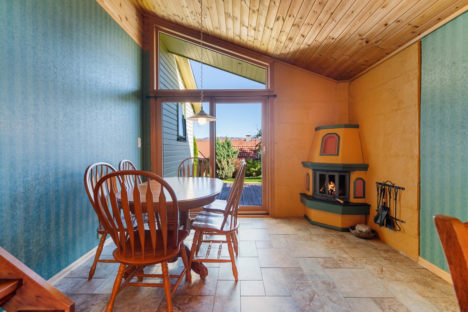 Ildsted oppført som hjørnepeis på kjøkkenet. Videre utgang til terrasse og hage. Galleribilde