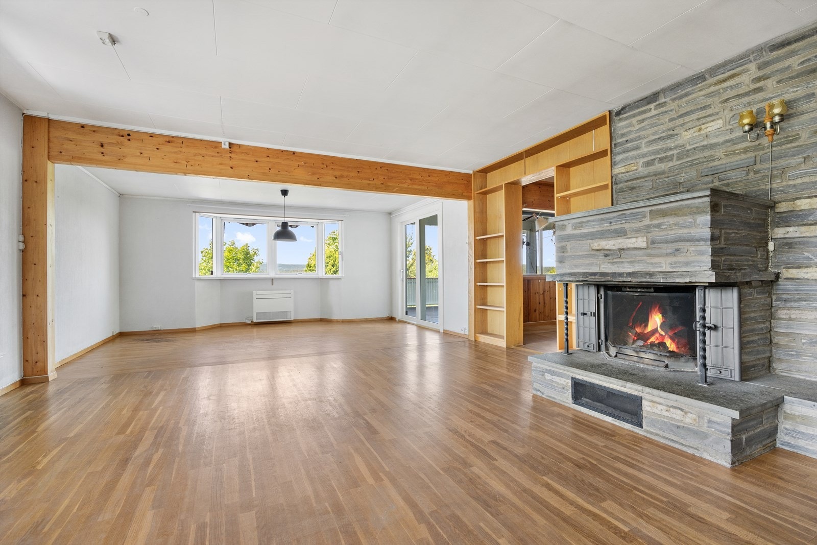 Stuen har hvitmalte overflater og fondvegg av panel, samt skifer i forbindelse med peisen. Galleribilde