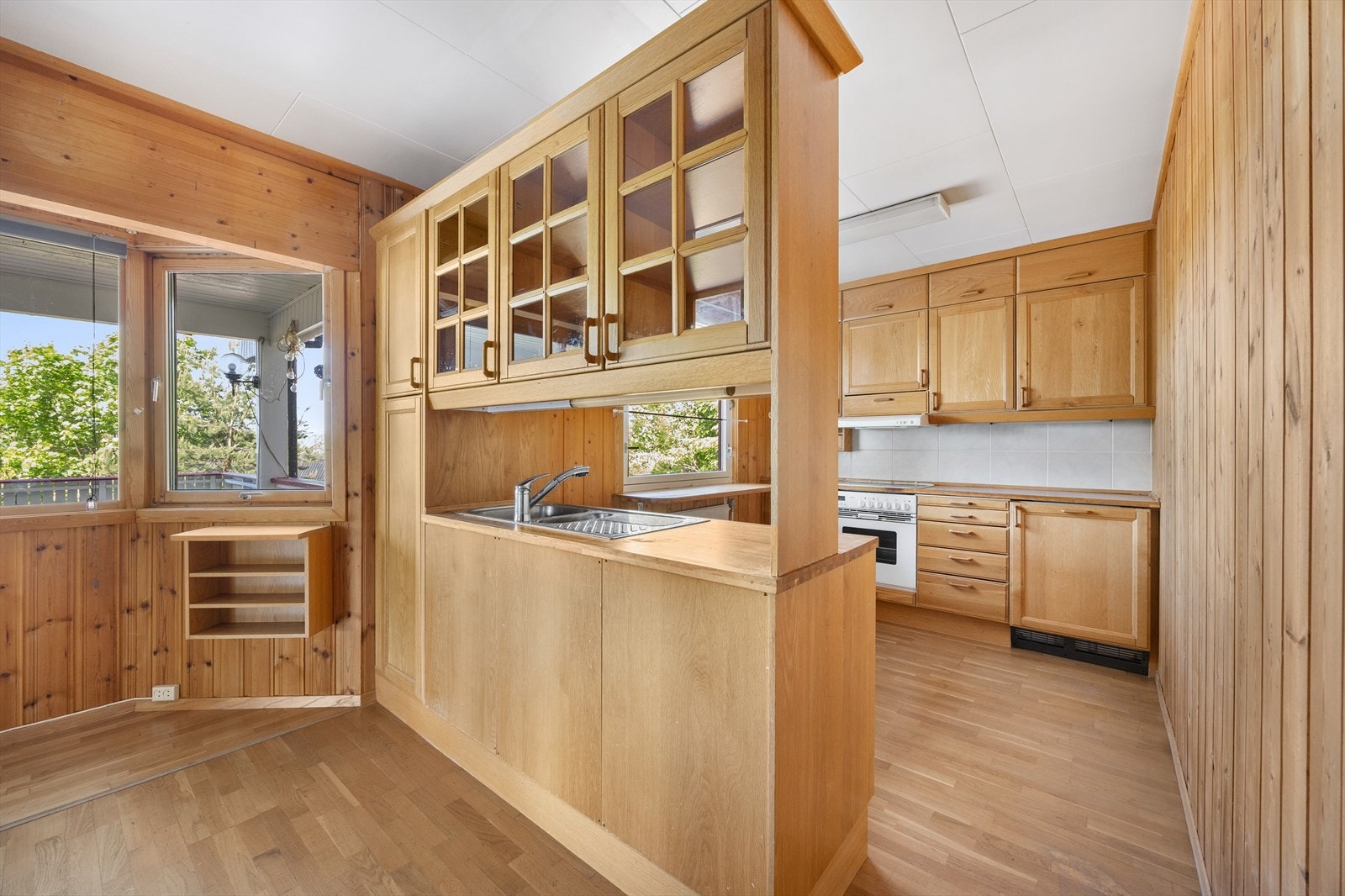 Kjøkkenet har profilerte fronter, vitrineskap og benkeplater av heltre. Galleribilde