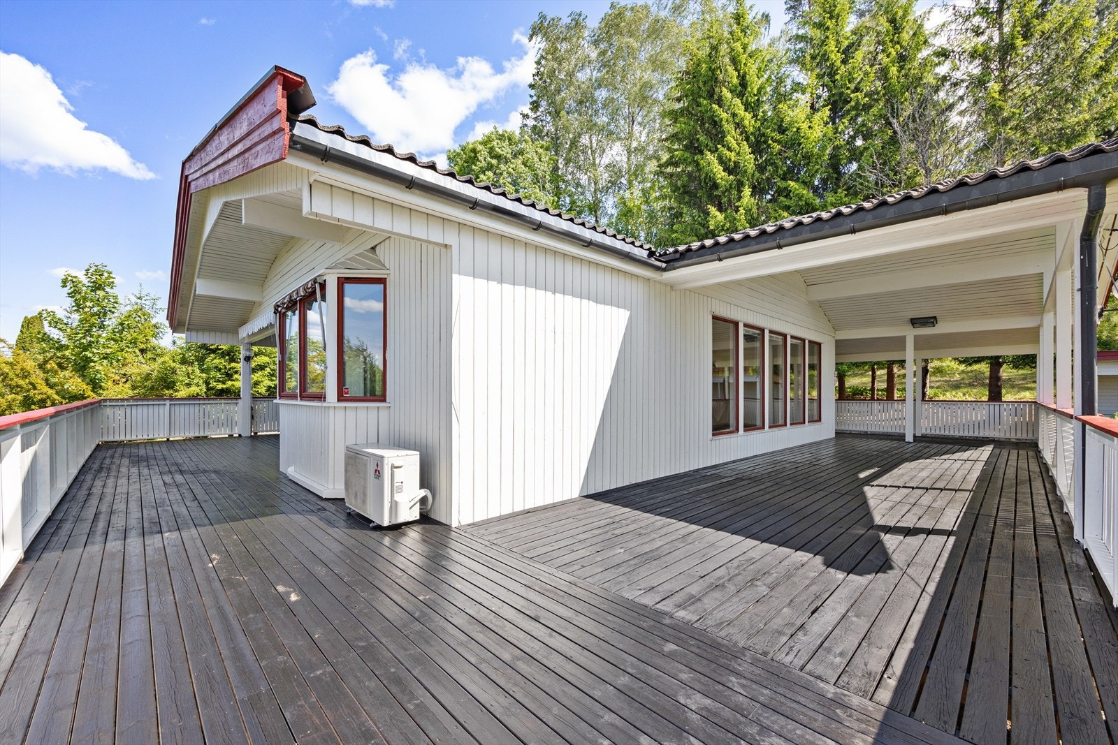 Verandaen er romslig og vinkler seg rundt boligen frem til inngangspartiet. Galleribilde