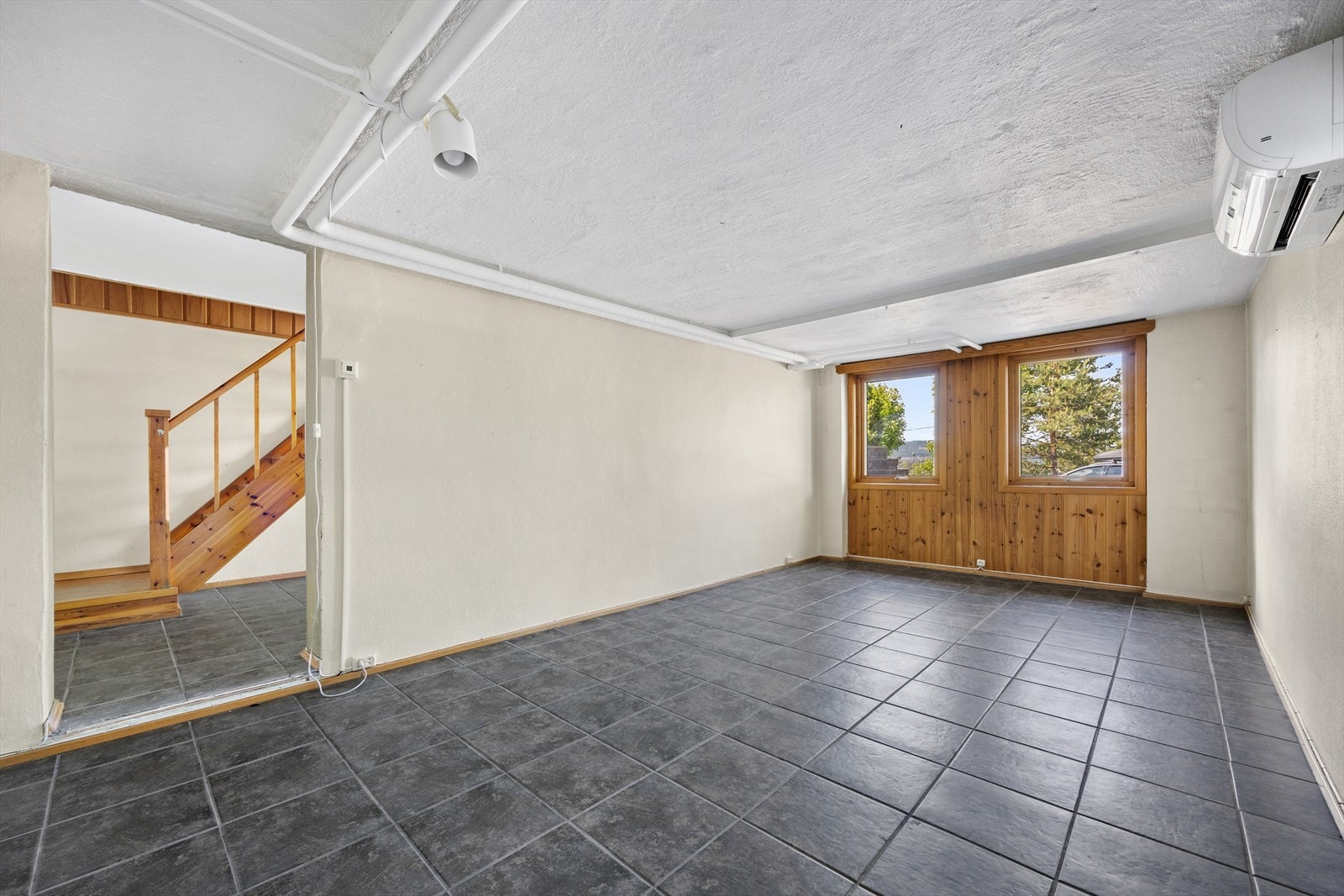 Praktisk underetasje med egen flislagt inngang, to innredet rom og installert varmepumpe. Galleribilde
