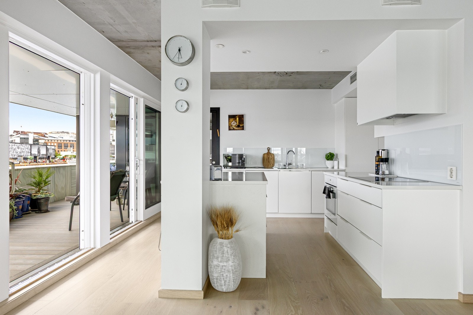 Benkeplate og sideflater til kjøkkenøy er i slitesterk steinplater fra Silestone med underlimt oppvaskkum og Glamitec-plater på vegg over kjøkkenbenkene. Galleribilde