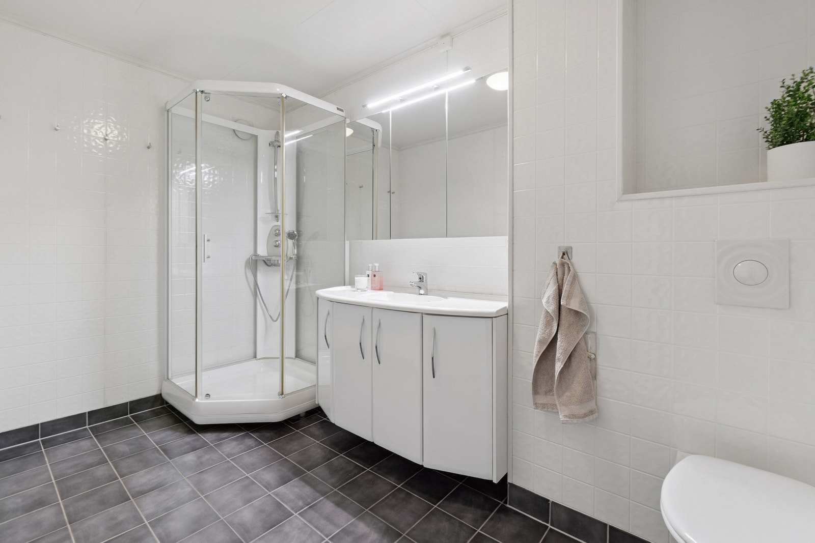 Badet fremstår tidløst og har bl.a. vegghengt toalett, dusjkabinett og servantskap. Galleribilde