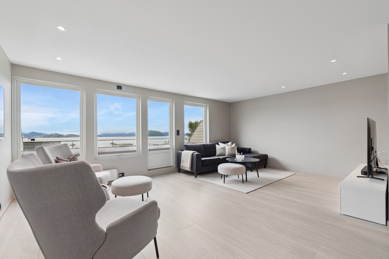 Stuen føles luftig takket være en åpen planløsning og store vindusflater som gir rikelig med lysinnslipp, noe som komplimenterer stuens moderne utførelse. Galleribilde