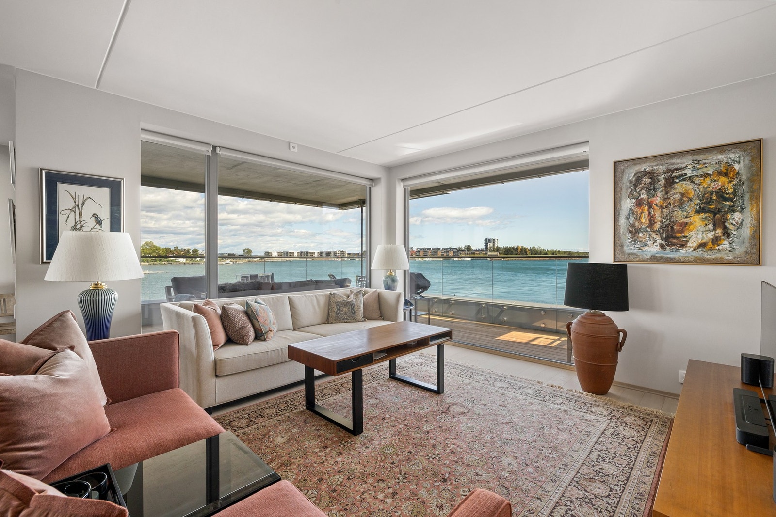 Store vindusflater ned til gulvet slipper inn rikelig med dagslys og rammer inn panoramautsikten mot sjøen, som følger deg overalt i rommet.