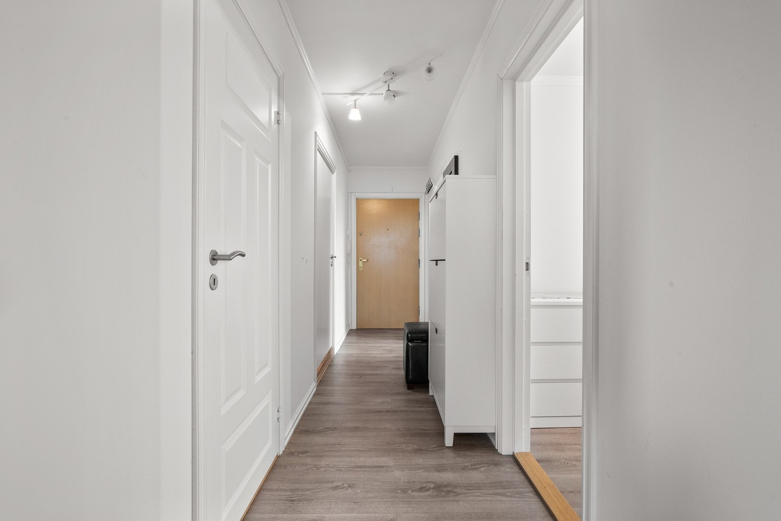 Velkommen hjem! Dette er en innbydende entré som fungerer som et naturlig knutepunkt til boligens øvrige rom. Galleribilde