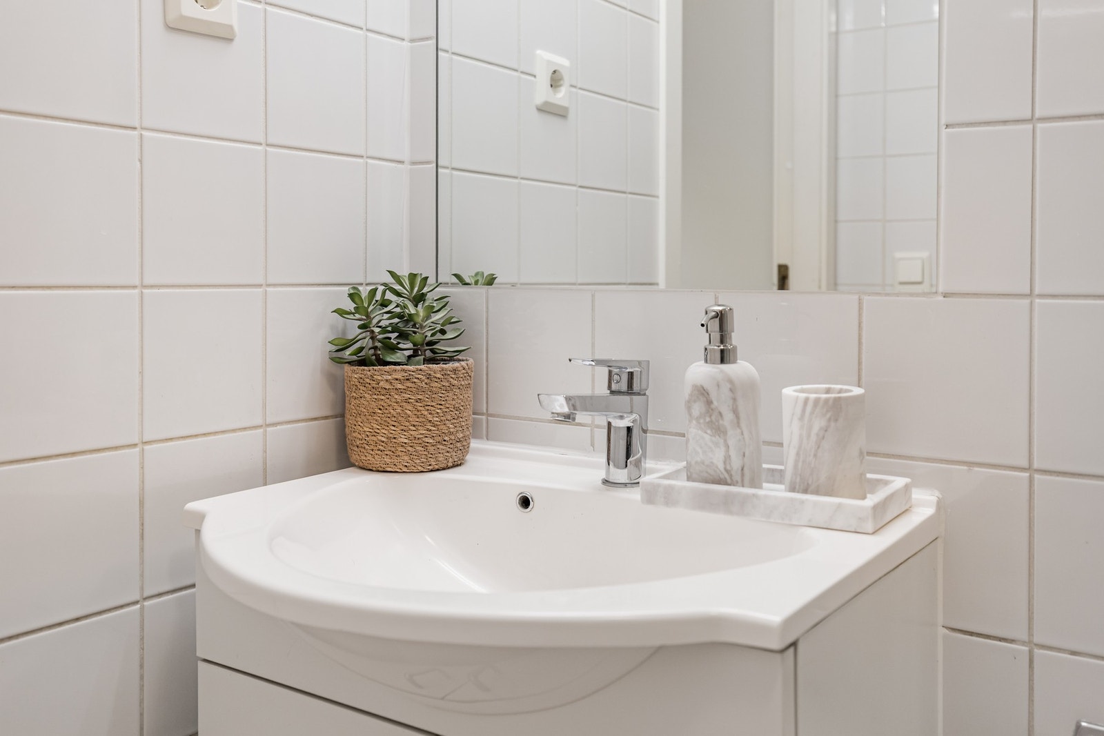 Baderommet inneholder, servant med skap, speil, veggmontert wc, dusjhjørne og opplegg for vaskemaskin/trommel. Galleribilde