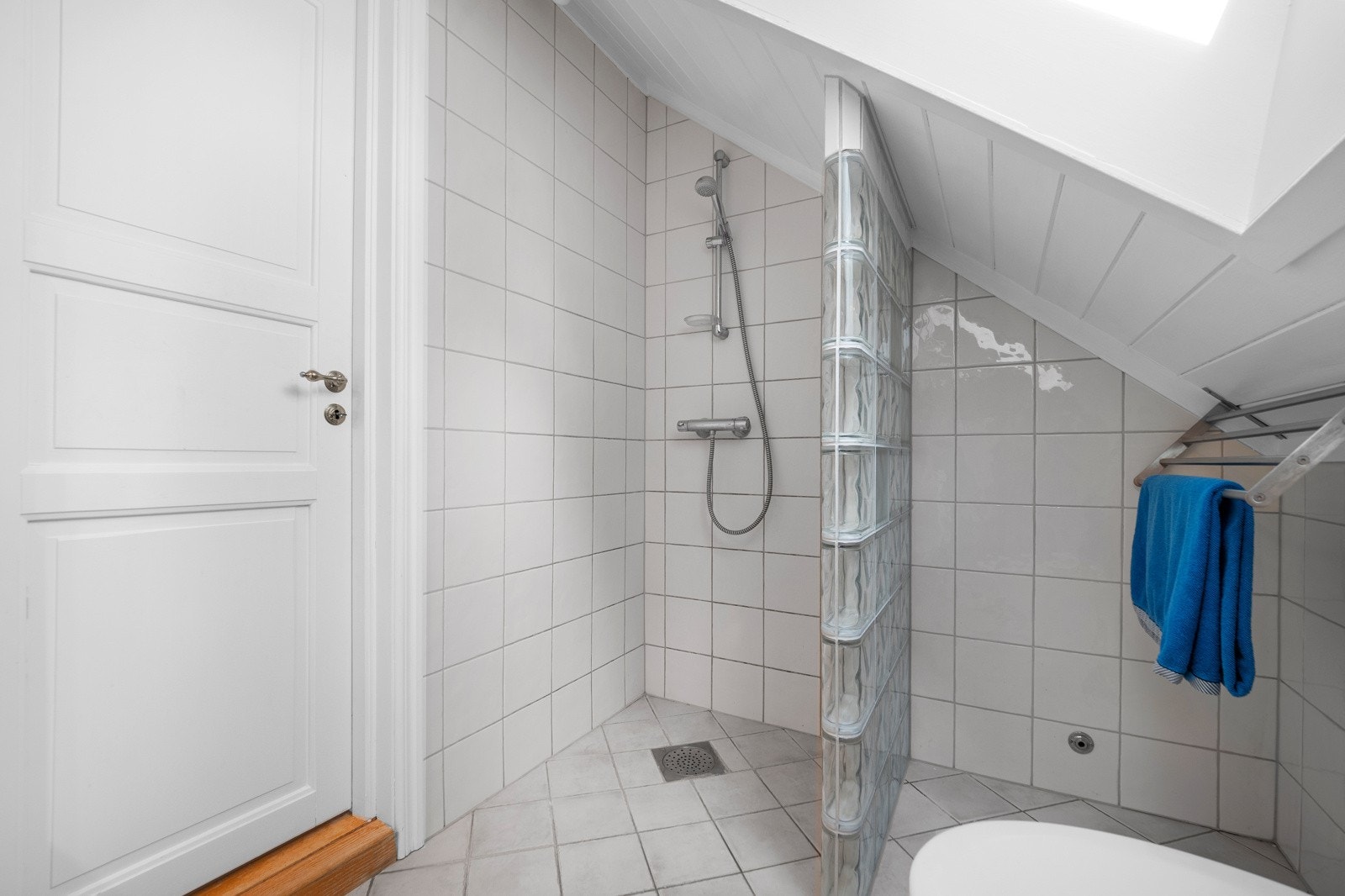 Badet er innredet med servantskap, servant, toalett og dusjhjørne Galleribilde