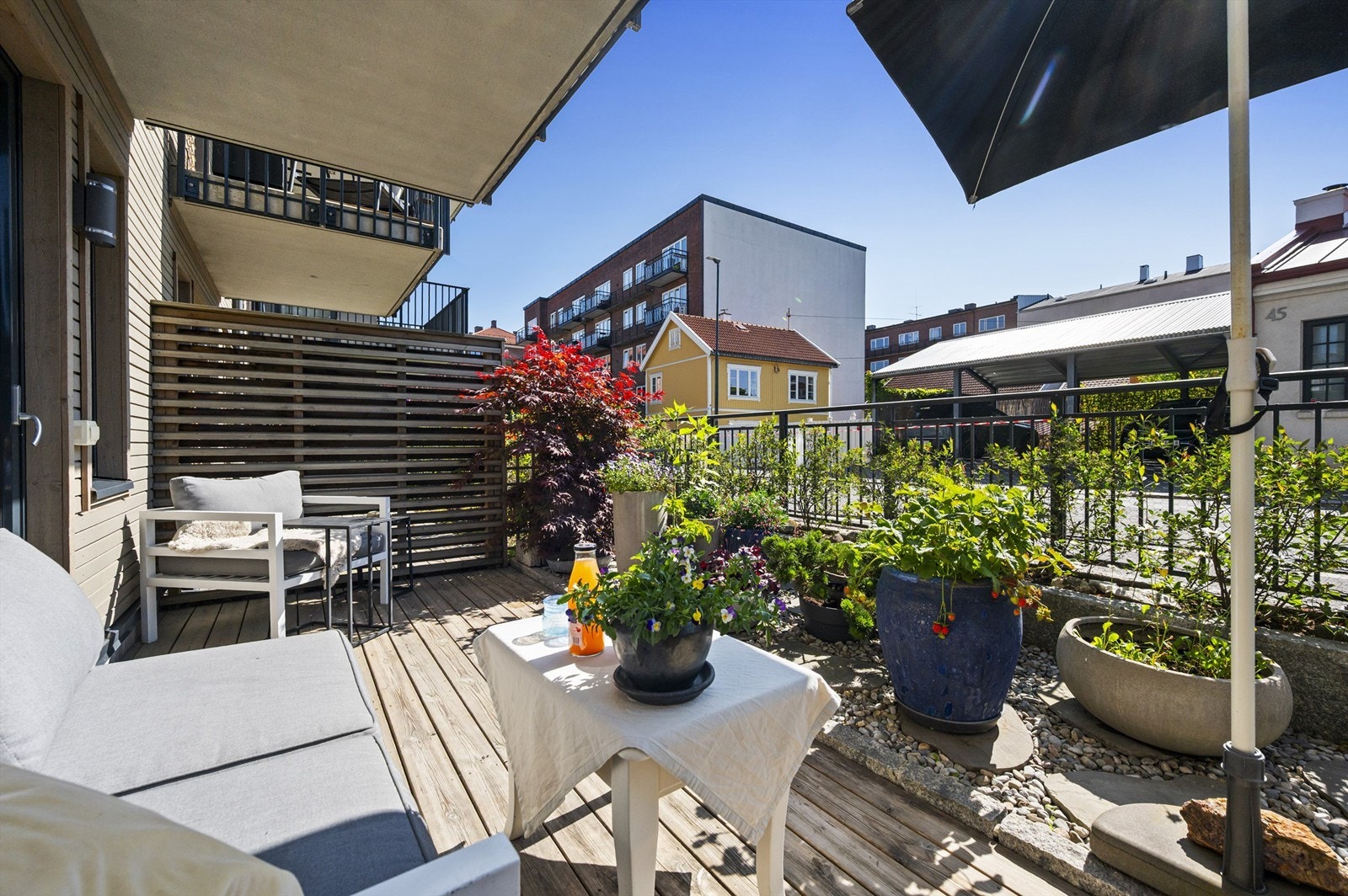 Terrassen mot rolige Fjellgata er en idyllisk oase med nydelig utsikt over hyggelig trehusbebyggelse. Plass til sittegrupper, planter og grill. Her er det sol fra morgen til ca 15.30. Galleribilde