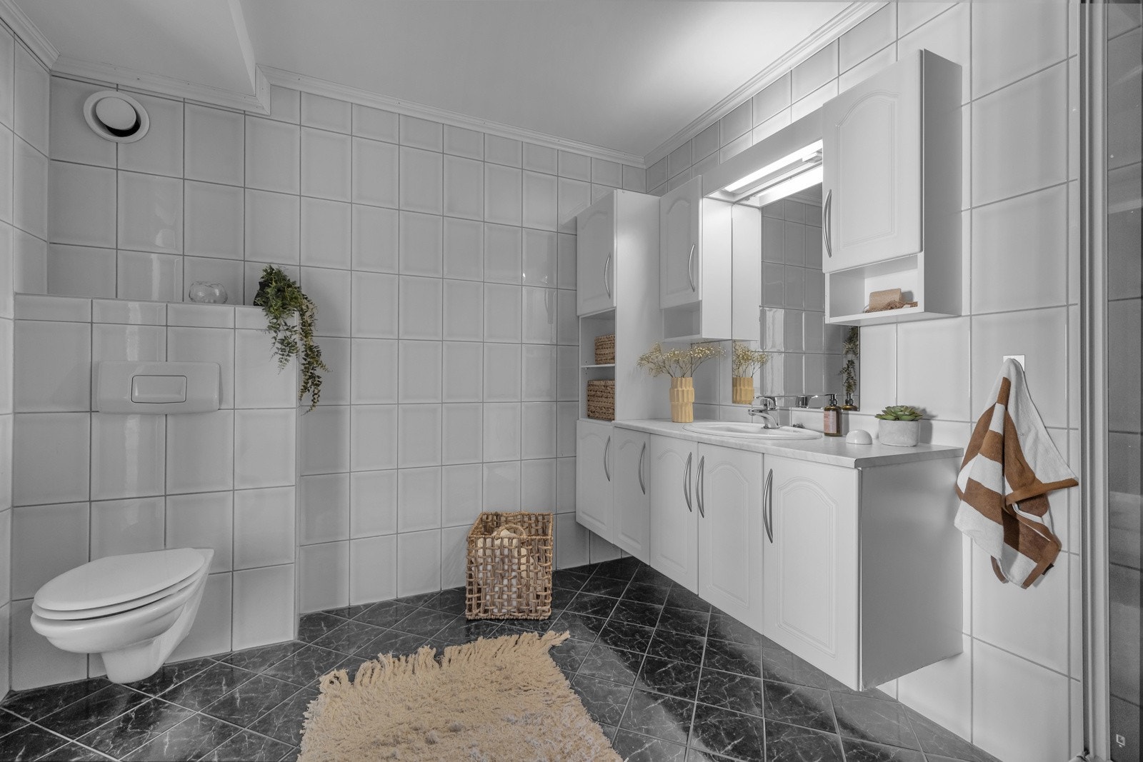 Badet i hovedleiligheten er flislagt på gulv og vegger Galleribilde