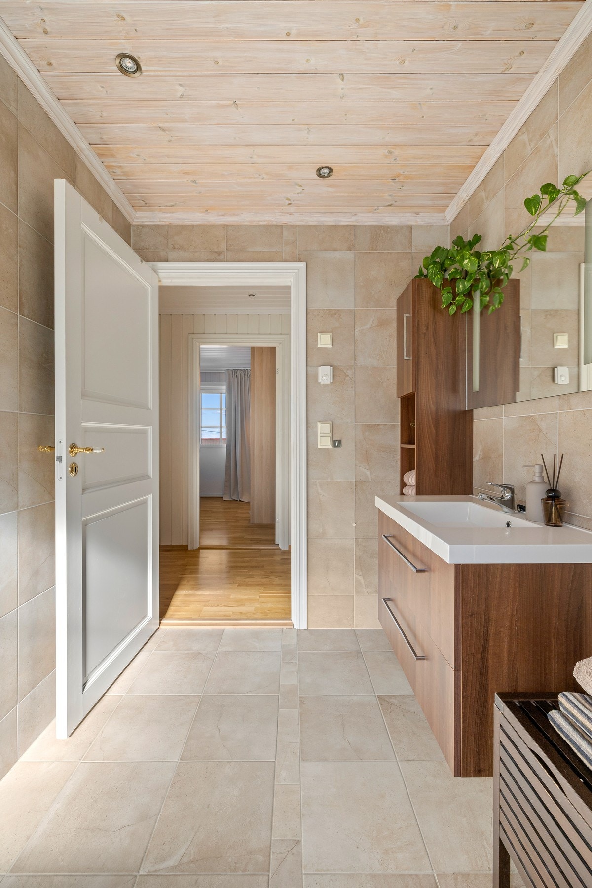 Badet har et vegghengt toalett, mekanisk avtrekk og et dusjhjørne med innfellbare glassdører. Galleribilde