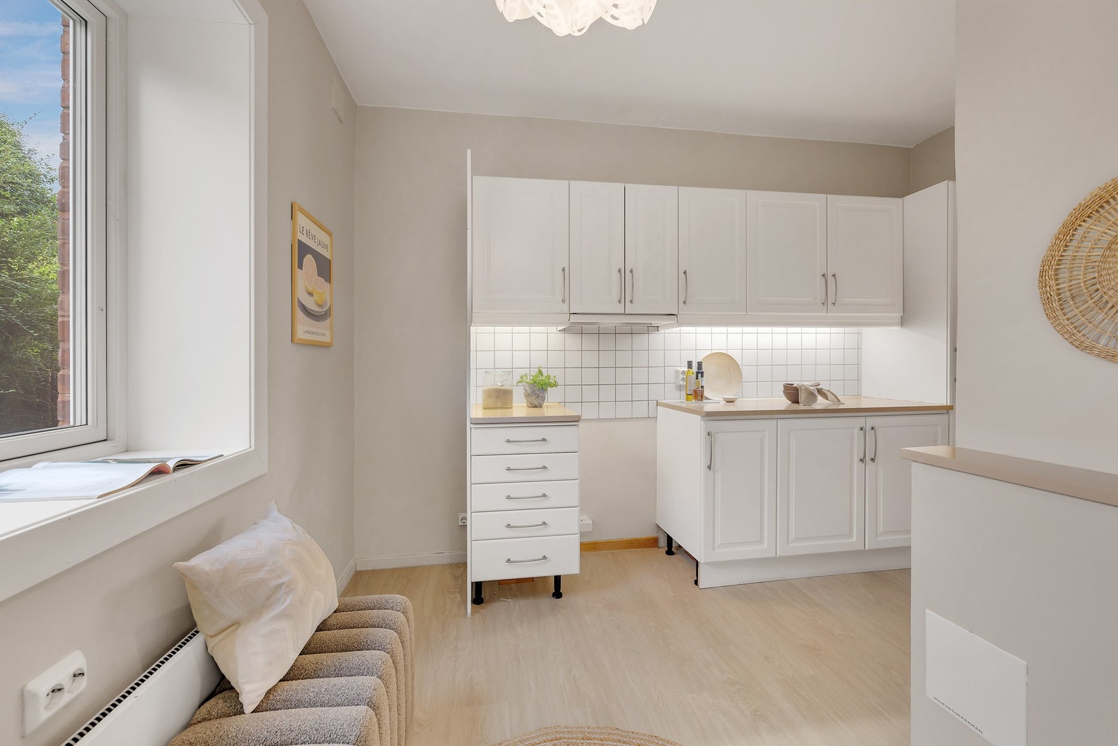 Kjøkkeninnredning med hvite, profilerte fronter og heltre, malt benkeplate. Galleribilde