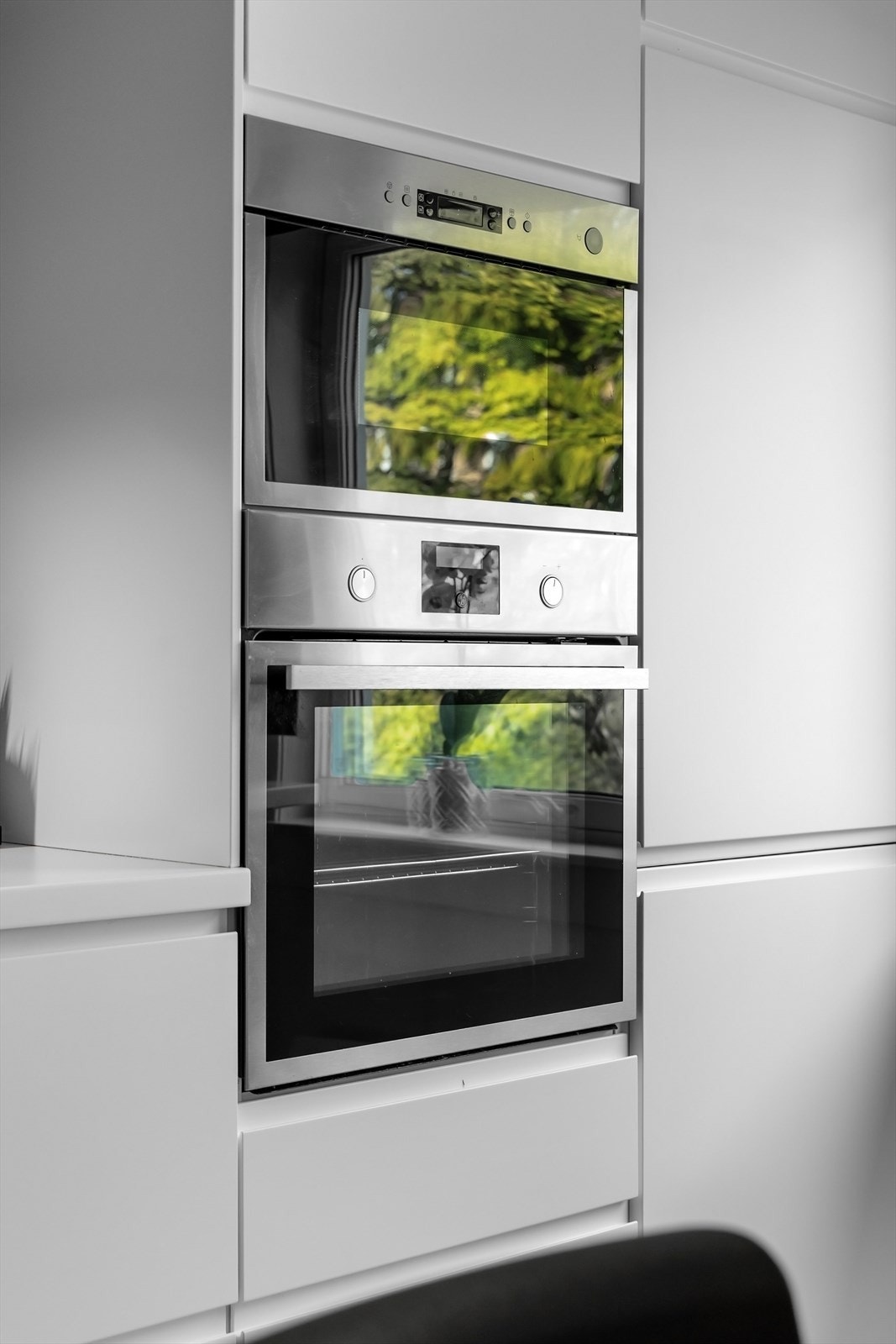 Kjøkkenet har integrerte hvitevarer som induksjon koketopp, stekeovn, mikrobølgeovn, kjøleskap/fryser og oppvaskmaskin Galleribilde